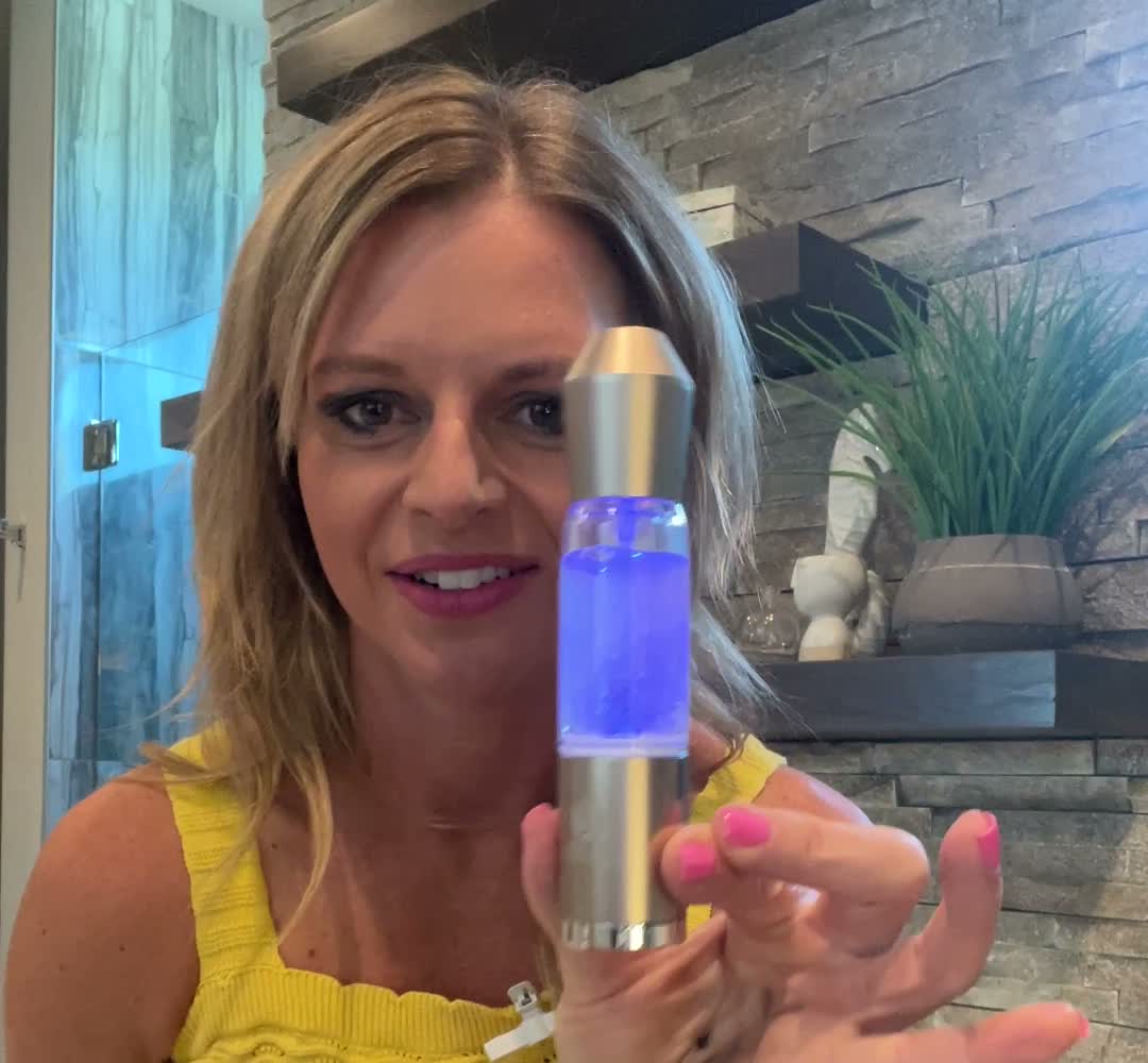 Woman holding the illuminated Hydra Mist facial mister